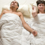 Man snoring bothering his sleep partner